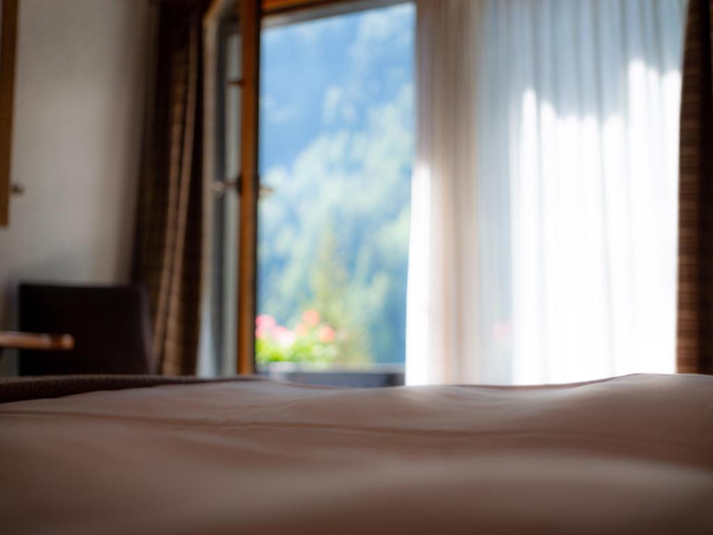 Postel nebo postele na pokoji v ubytování Hôtel Cristal - Swiss Riders Lodge Grimentz