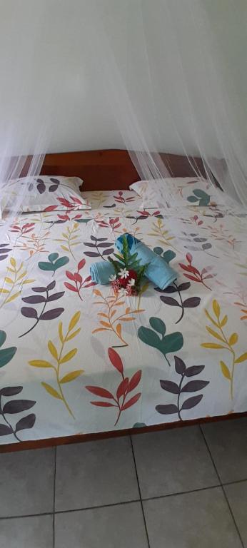 Una cama con colcha floral encima. en Penu Maurua 3 en Te-Fare-Arii