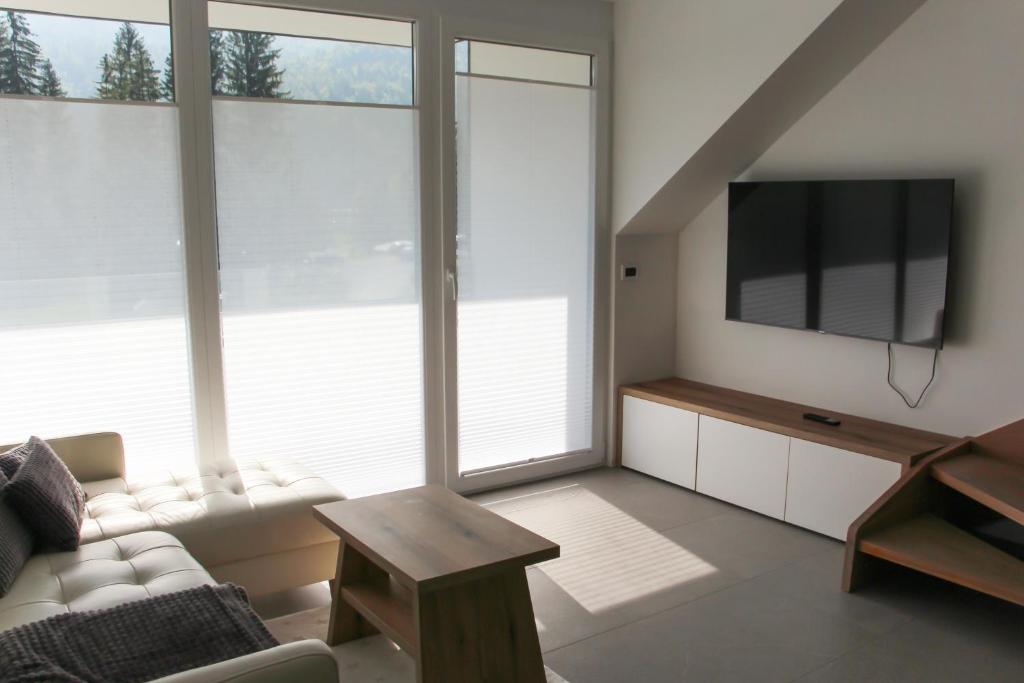 a living room with a couch and a flat screen tv at Apartment Simona in Kranjska Gora