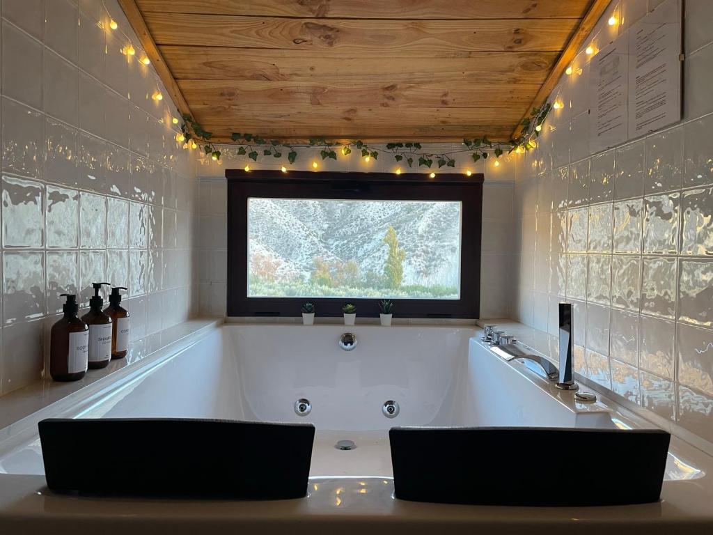 a bathroom with a tub with two chairs in it at La Rosita alojamiento rural in Hinojares