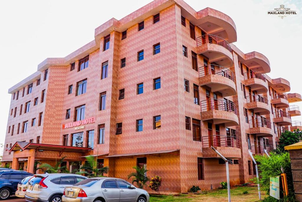 un edificio con coches estacionados frente a él en Maxland Hotel, en Nairobi