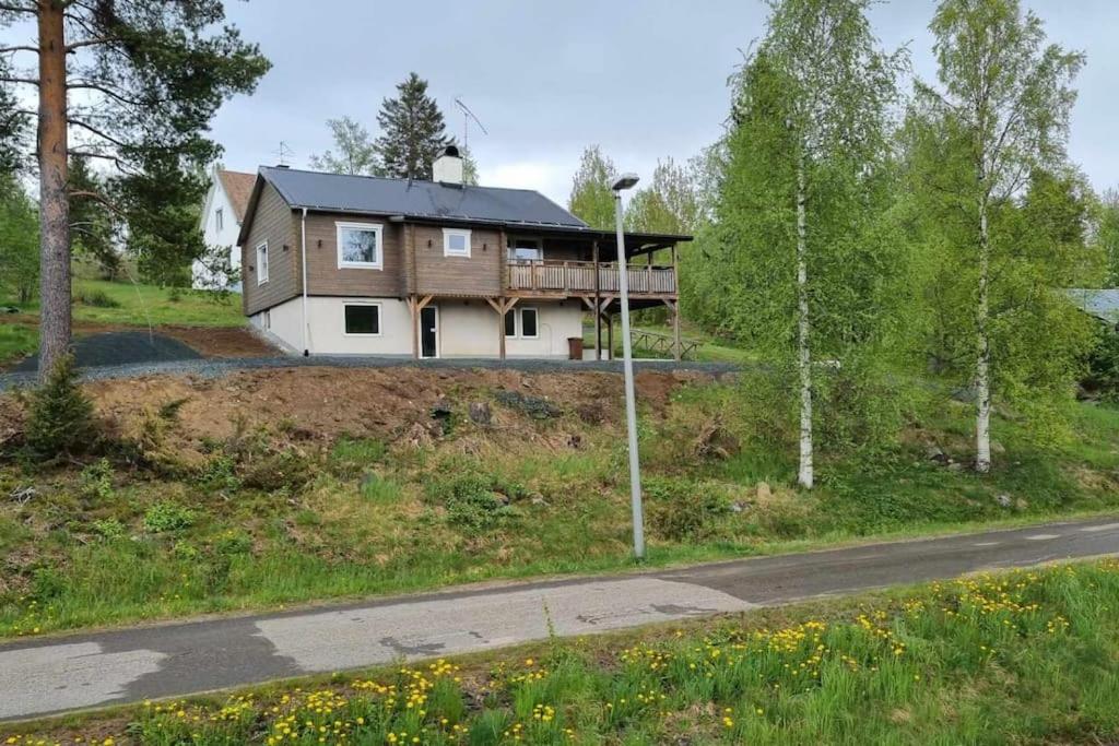 a house on the side of a hill with a road at Fantastisk Stuga i Hälsingland, Los! in Los