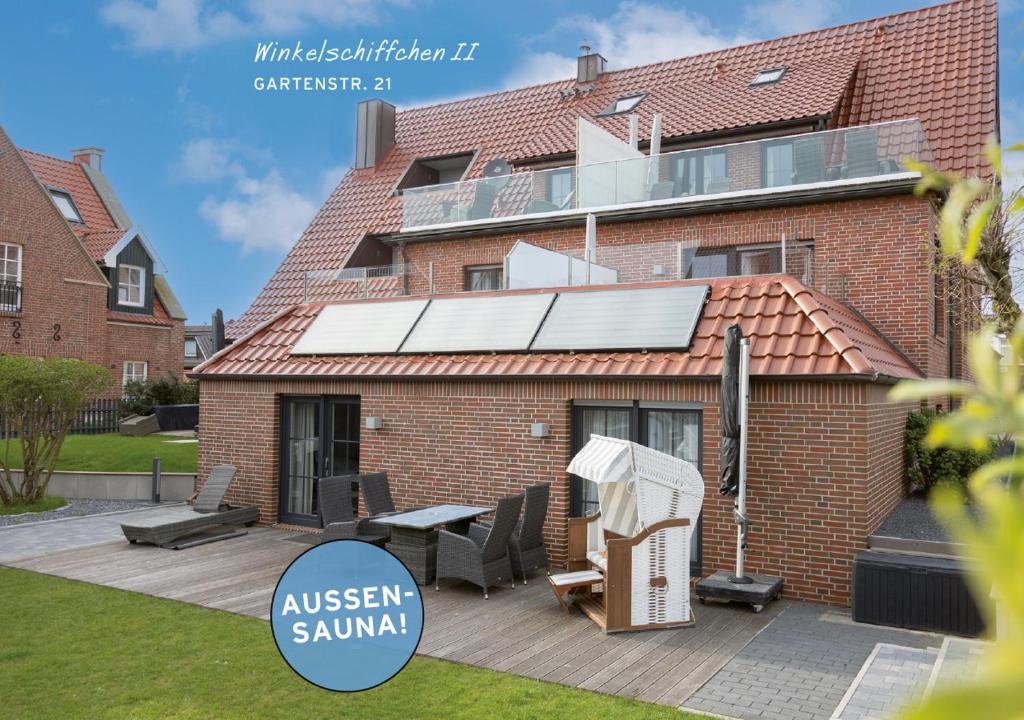 uma casa com painéis solares no telhado em Winkelschiffchen II mit Sauna em Juist