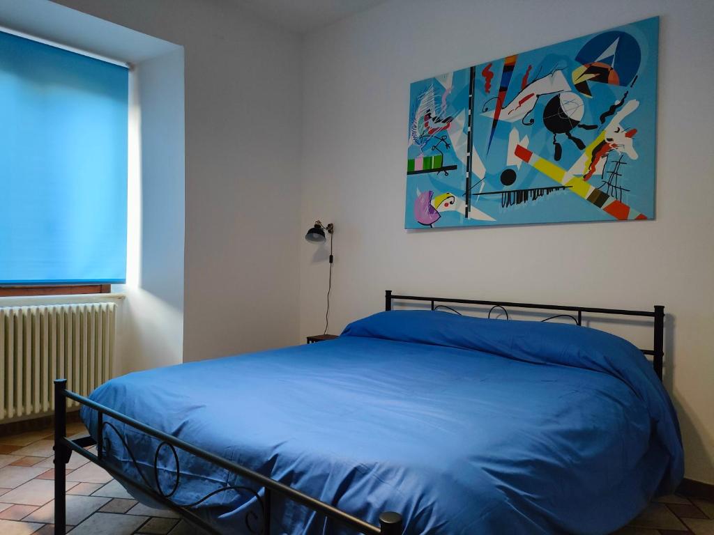 拉奎拉的住宿－Appartamento Fontesecco，卧室配有一张床,墙上挂有绘画作品