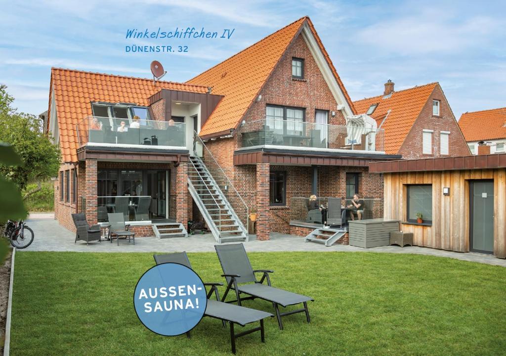 a large house with a deck and a patio at Winkelschiffchen IV mit Sauna in Juist