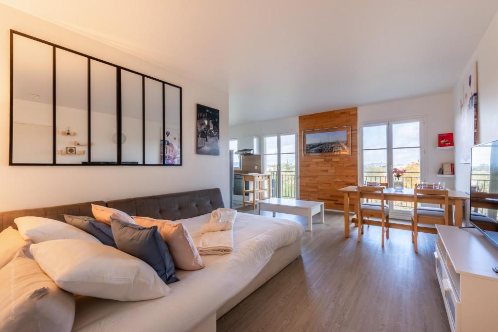 un salon avec un canapé et une salle à manger dans l'établissement City Of Love By Plaza - Proche Disneyland Paris, à Serris