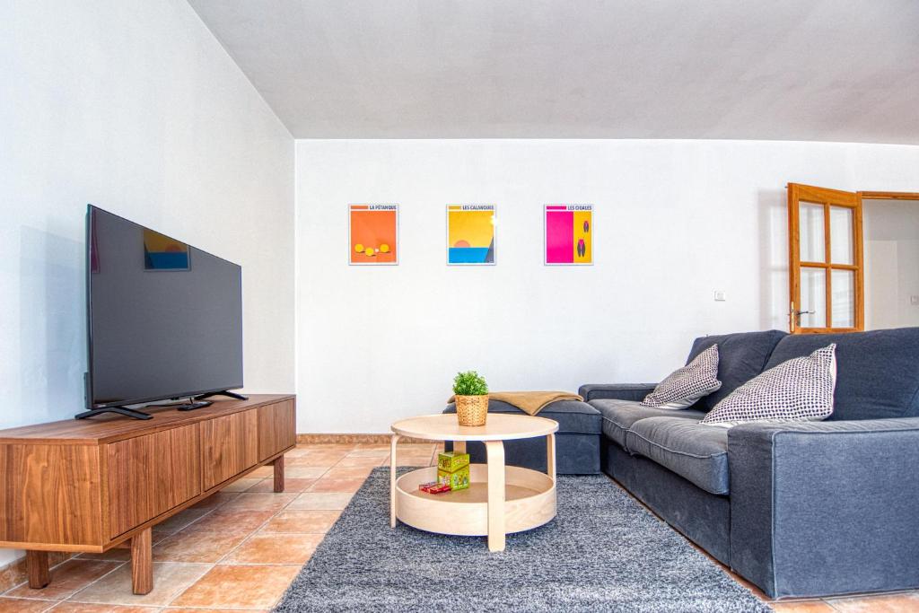 sala de estar con sofá azul y TV en Villa provençale proche mer, en Martigues