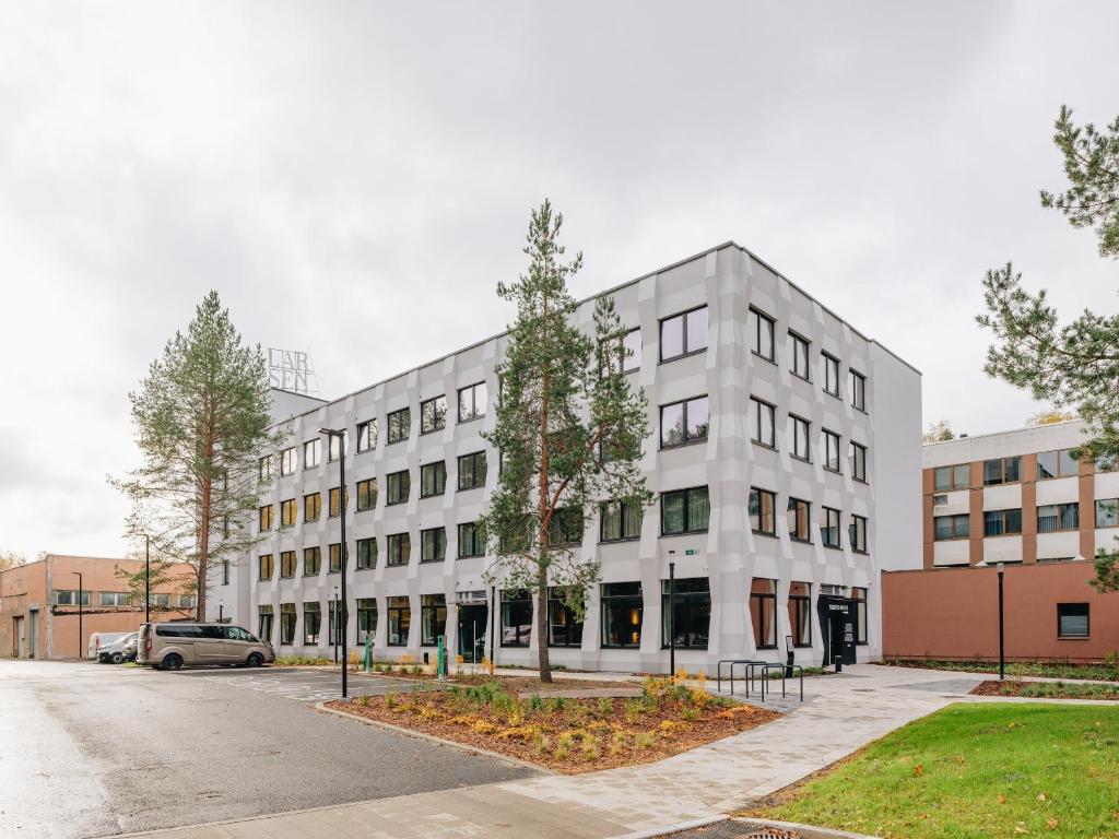 a white building with trees in front of it at Stereo House by Larsen in Tallinn