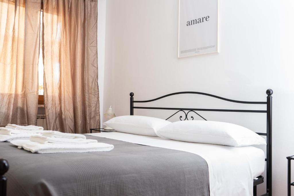 a bedroom with a bed with white sheets and pillows at Prestige White Apartment in Cassino