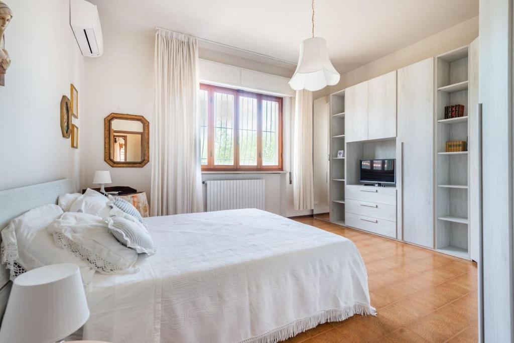 - une chambre blanche avec un lit blanc et une fenêtre dans l'établissement Villa Giulia, à Capannori