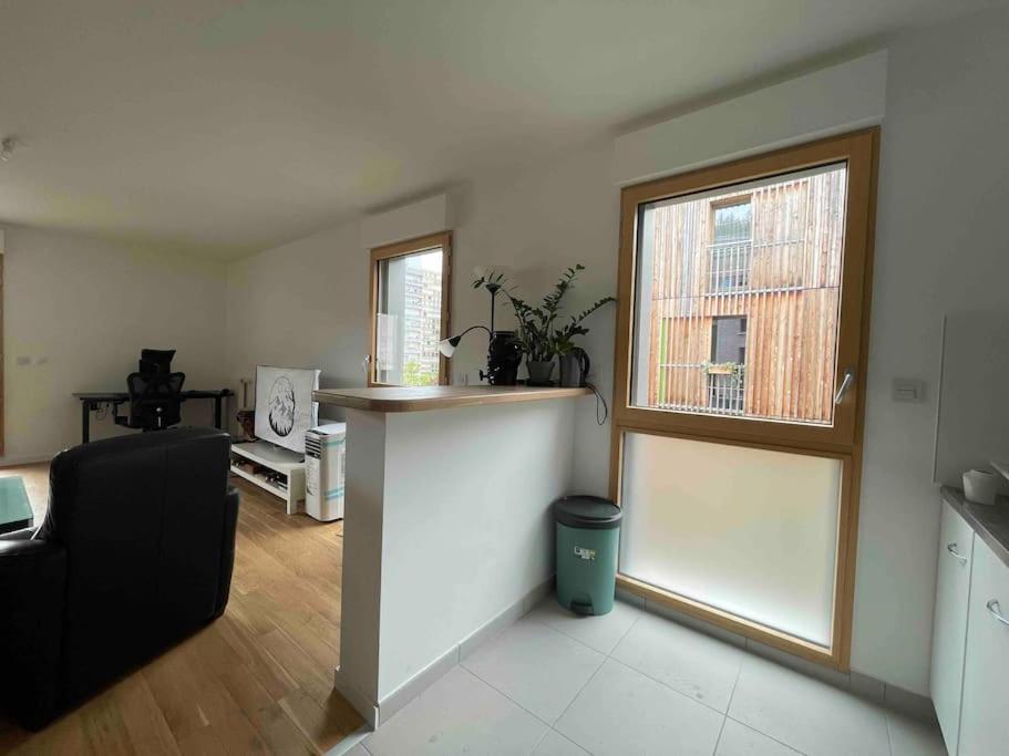 a living room with a counter and a window at Magnifique logement avec terrasse &amp; climatisation in Aubervilliers