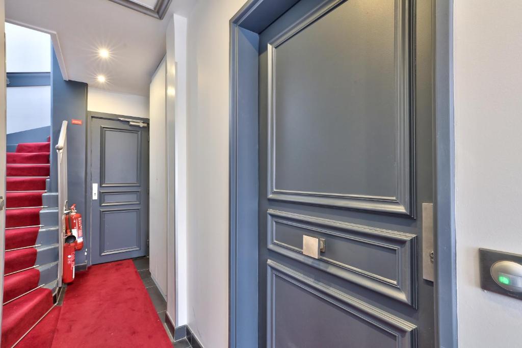 a hallway with a blue door and red carpet at Charmant appartement à 10 min de la Défense in Suresnes