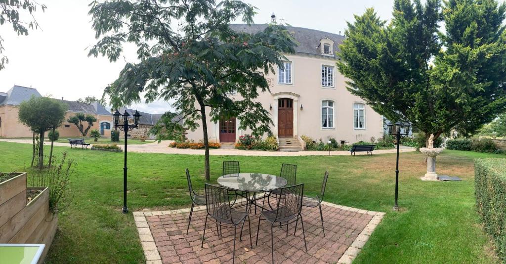 a table and chairs in front of a house at LE BAS CHITRAY in Ménil