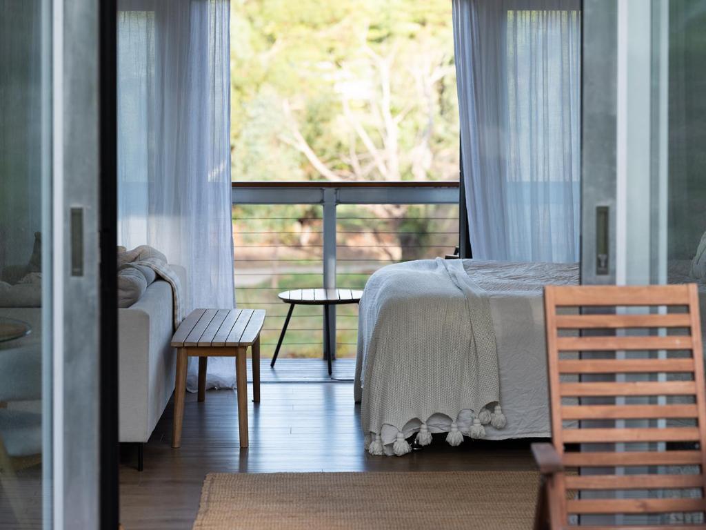 een slaapkamer met een bed en een groot raam bij The Villas - Barossa in Marananga