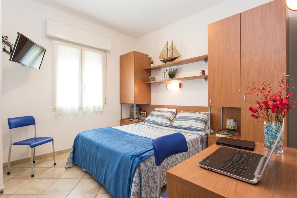 um quarto com uma cama e uma secretária com um computador portátil em Residence Veliero em San Mauro a Mare