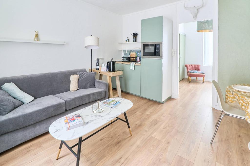 a living room with a couch and a table at LA LOGE DES CARMES -Coeur de Nantes WIFI in Nantes