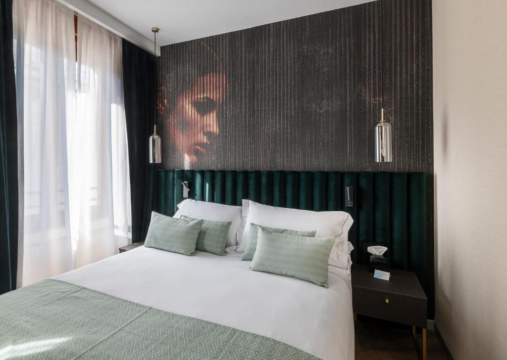 um quarto com uma cama branca e uma parede verde em Duomo Hotel & Apartments em Milão