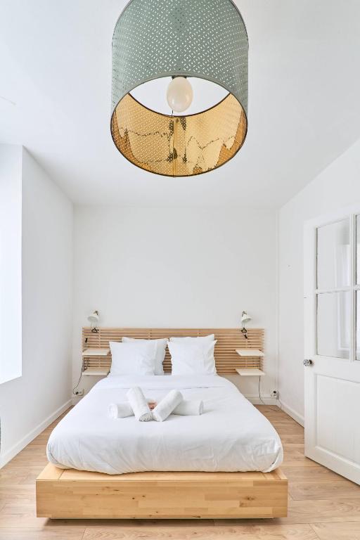 - une chambre avec un lit sous un grand éclairage dans l'établissement LA LOGE DES CARMES -Coeur de Nantes WIFI, à Nantes