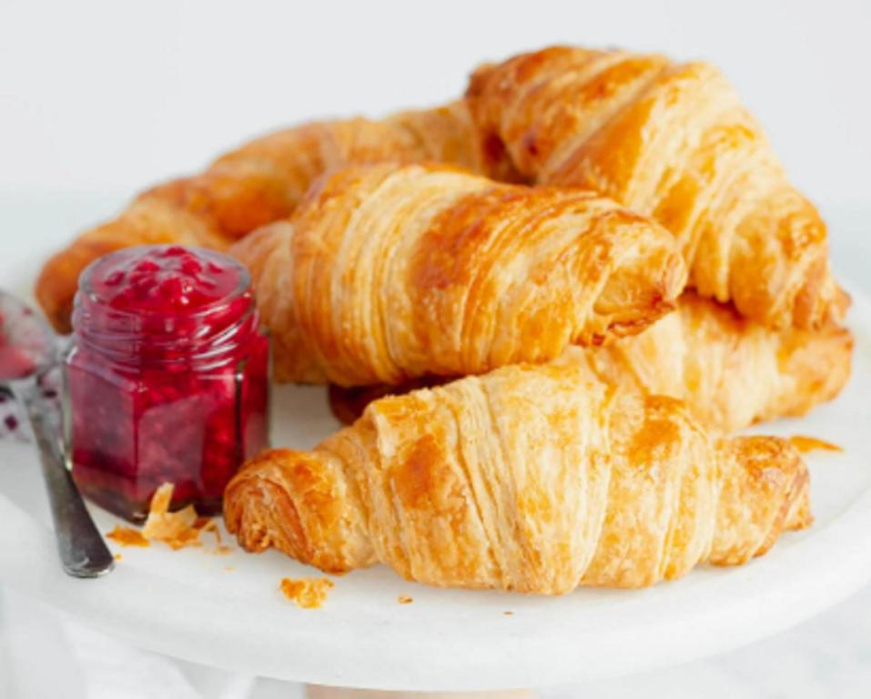 a white plate with croissants and a red jam at Wentworth Hotel in Aldeburgh