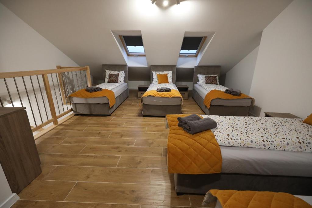 um quarto no sótão com 4 camas e uma varanda em ZABRZE Apartamenty Kościuszki 30 em Zabrze
