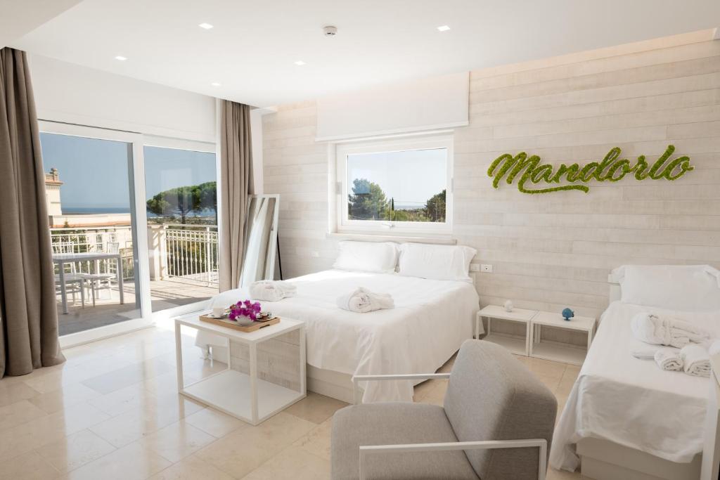 a bedroom with a white bed and a window with a sign at San Lorenzo Boutique Hotel & SPA in Polignano a Mare