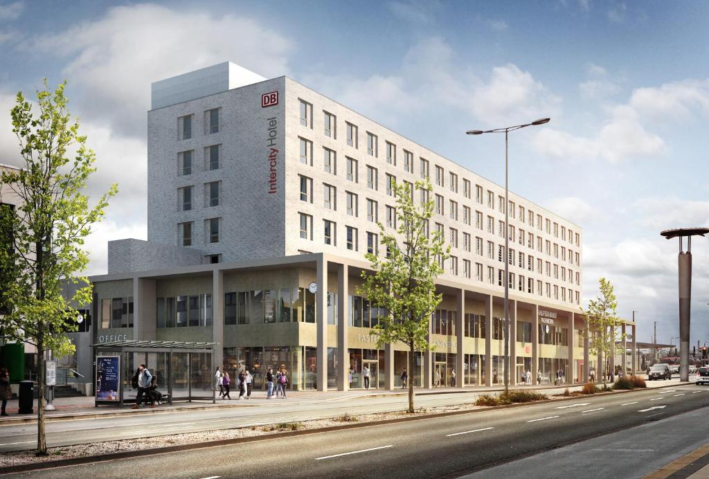 - un grand bâtiment blanc dans une rue de la ville dans l'établissement IntercityHotel Paderborn, à Paderborn