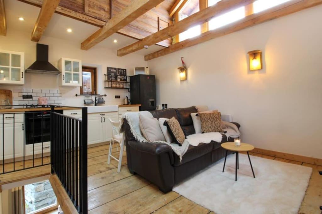 a living room with a couch and a kitchen at Charmante maison de hameau traditionnel montagnard in Saint-Marcel