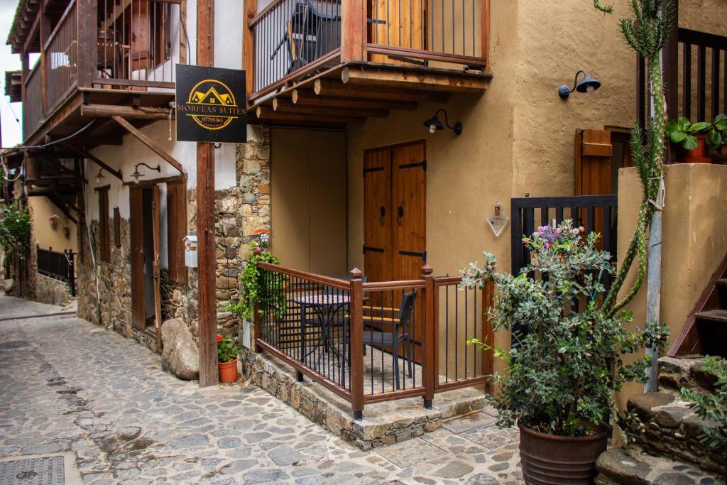 a building with a balcony and a chair on a street at Morfeas Kakopetria in Kakopetria