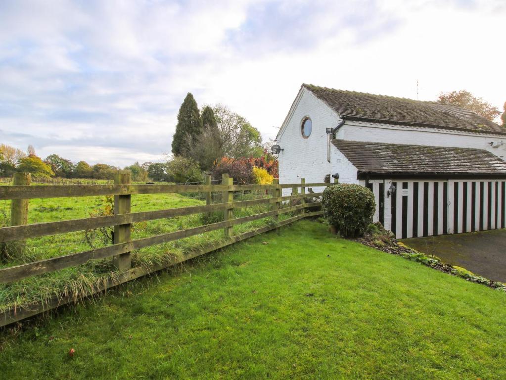 a barn and a fence next to a house at The Beehive in Crewe