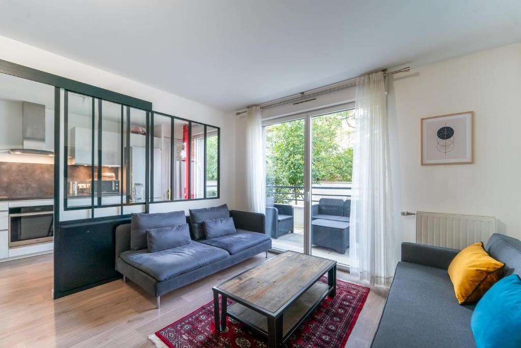 uma sala de estar com um sofá e uma mesa em Le Arty - 20 mn de Paris et d'Orly em Vitry-sur-Seine