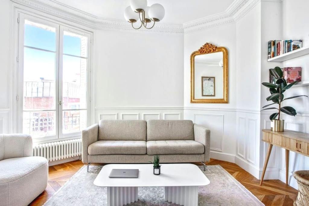 ein Wohnzimmer mit einem Sofa und einem Tisch in der Unterkunft Luxury typical Parisian apartment in Saint-Ouen