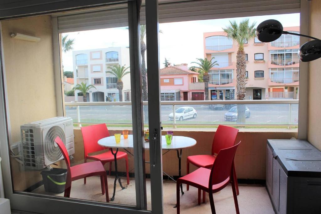une table et des chaises dans une pièce avec une fenêtre dans l'établissement Agréable appartement T2 avec loggia proche commerces et plage - 4ALB24, à Saint Cyprien Plage
