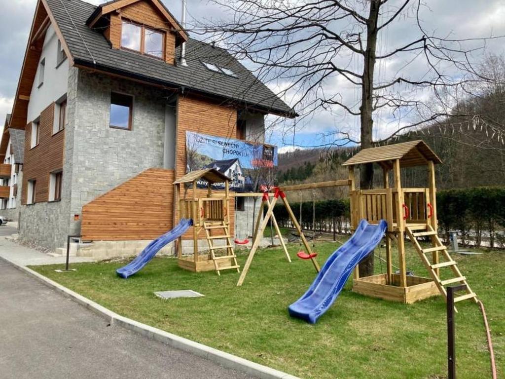 a group of playground equipment in front of a house at Apartmány Vodohospodár in Mýto pod Ďumbierom