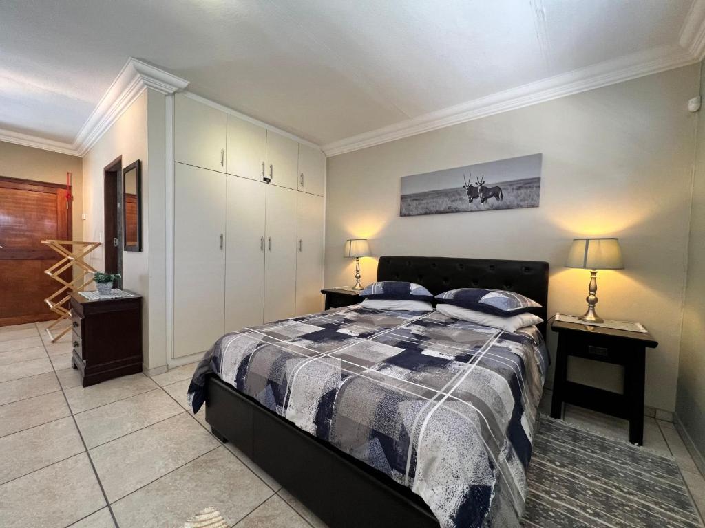 1 dormitorio con 1 cama y 2 lámparas en las mesas en Nomland en Walvis Bay