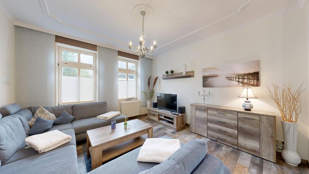 ein Wohnzimmer mit einem Sofa und einem TV in der Unterkunft strandnahe FeWo mit Terrasse, Villa Vergissmeinnicht 01, Binz in Binz