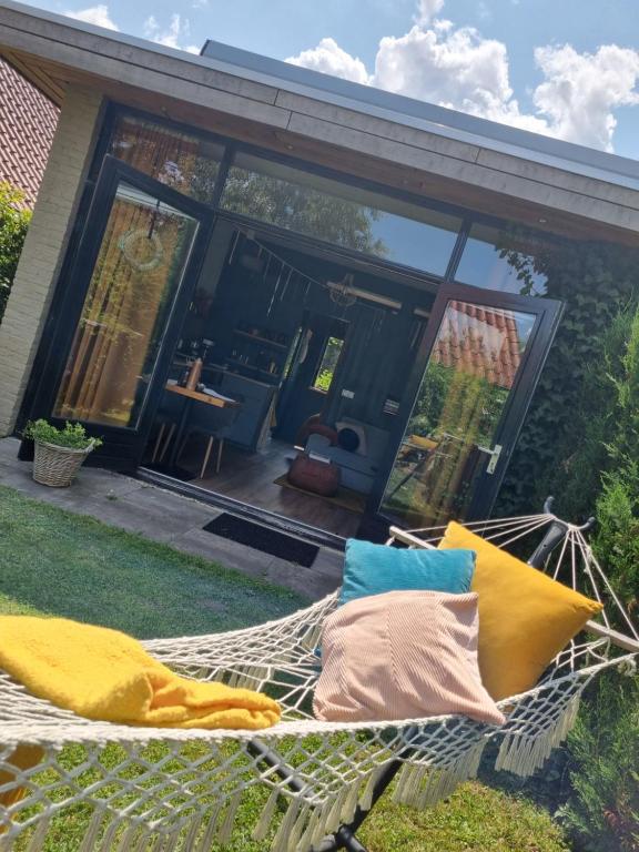 a hammock in the yard of a house at Tiny House in de Boomgaard in Stad aan ʼt Haringvliet