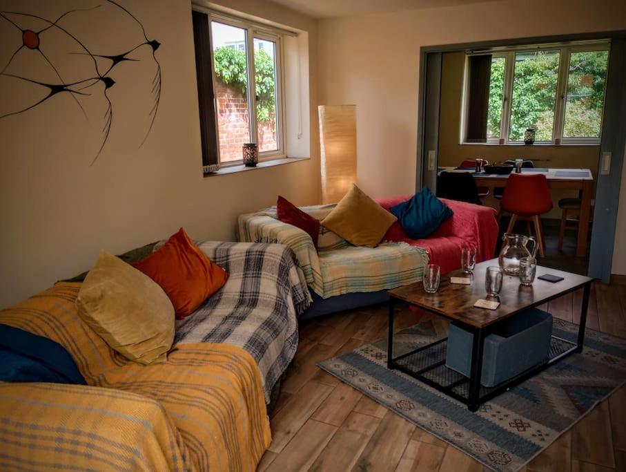 ein Wohnzimmer mit 2 Sofas und einem Tisch in der Unterkunft The Walled Garden in Long Melford