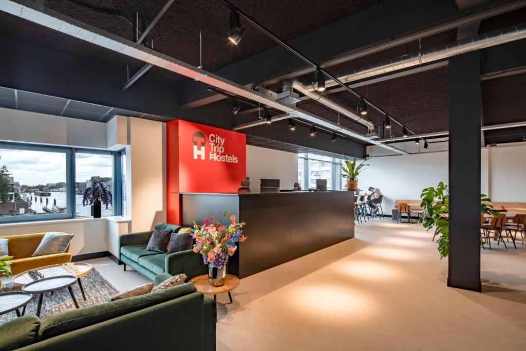 a lobby of an office with couches and tables at City Trip Hostels Zaandam-Amsterdam in Zaandam