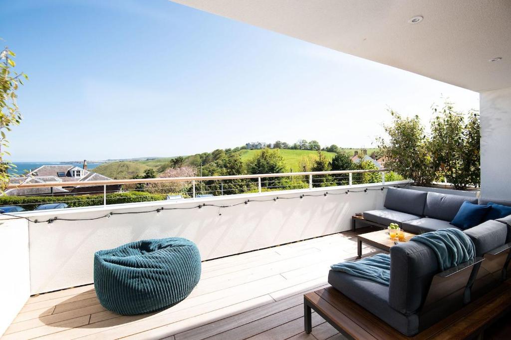 a balcony with a couch and a table at 2 The Bay in Coldingham