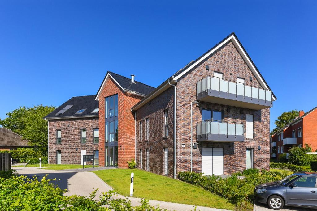 a brick building with a car parked in front of it at Ferienwohnung Ankerpause in Esens