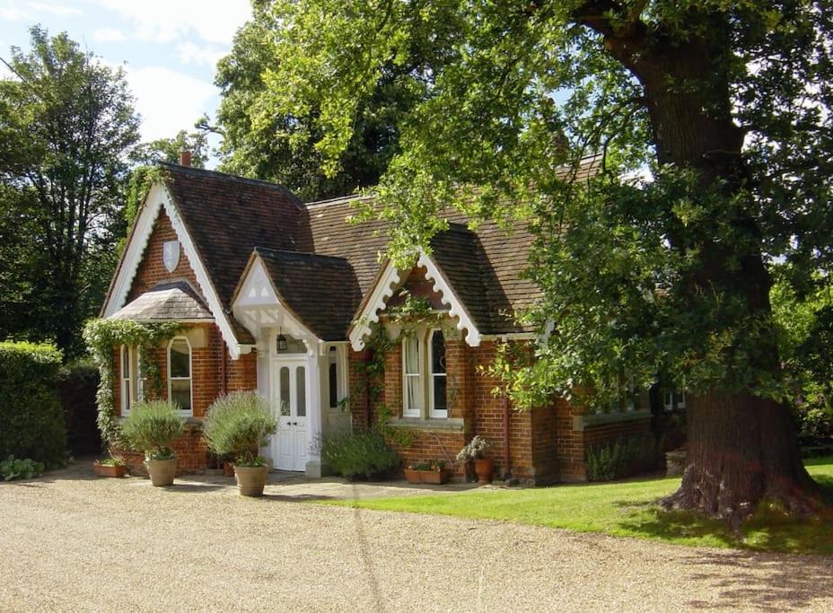 een stenen huis met een boom ervoor bij Gorgeous Country Cottage overlooking Windsor Castle in Old Windsor