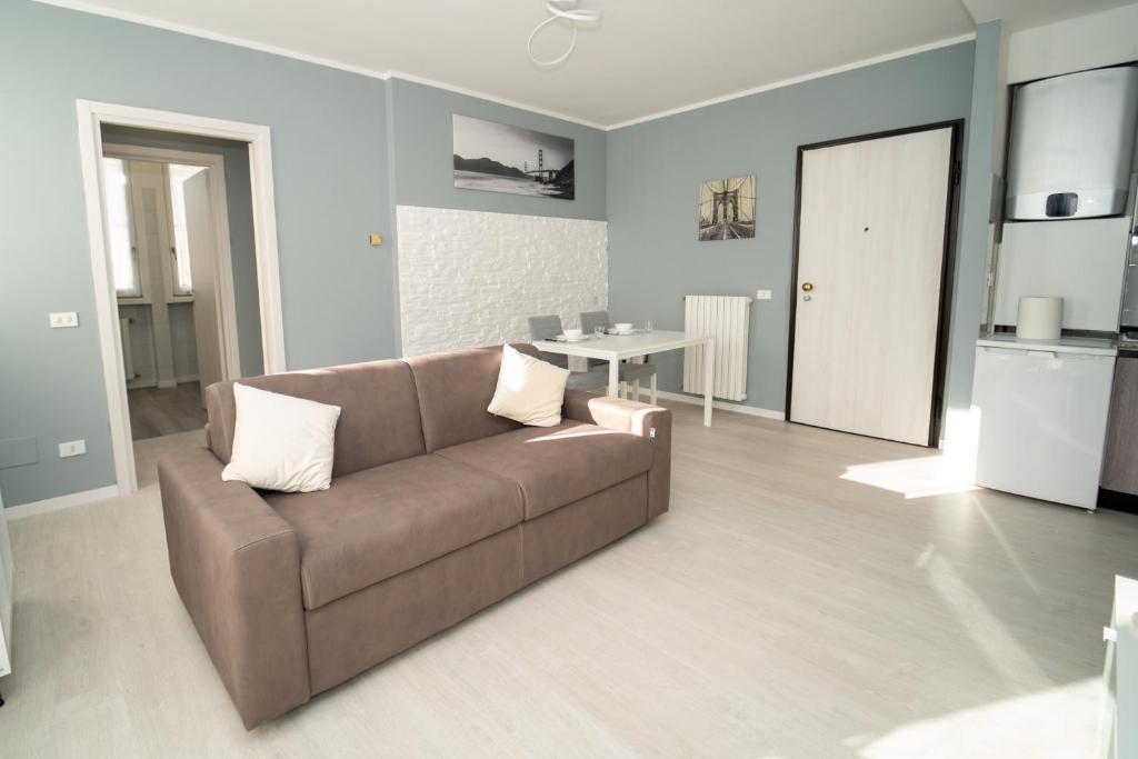 加拉瑞特COZY APARTMENT MALPENSA AiRPORT的客厅配有棕色沙发和桌子