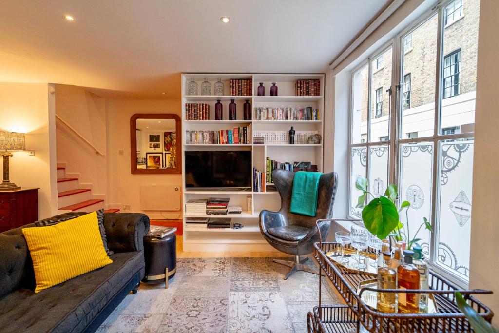 ein Wohnzimmer mit einem Sofa und einem Tisch in der Unterkunft Spacious West End Duplex Apartment, W1 Central London in London