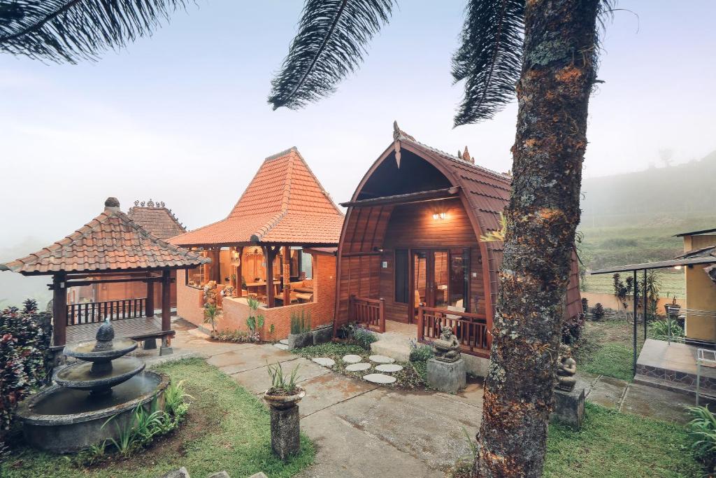 ein Haus mit einem Baum davor in der Unterkunft Tunjung Sari Villa Bedugul in Bedugul