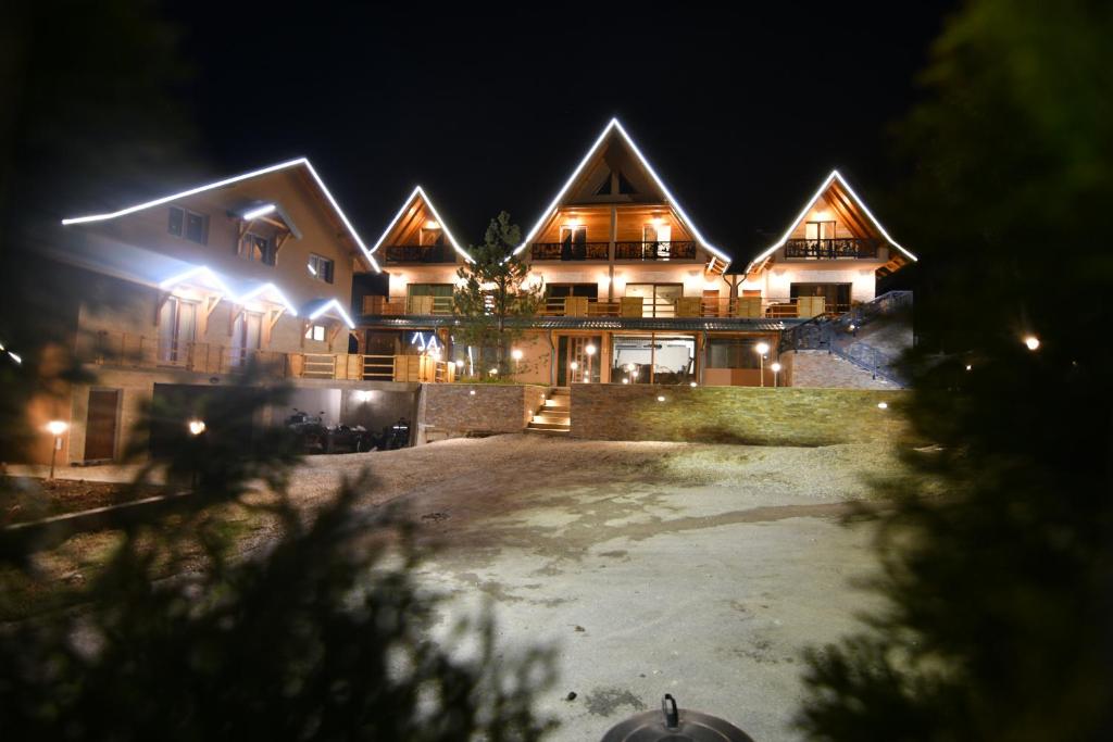 茲拉蒂博爾的住宿－Brvnara Mont 3，夜晚有灯的大木房子