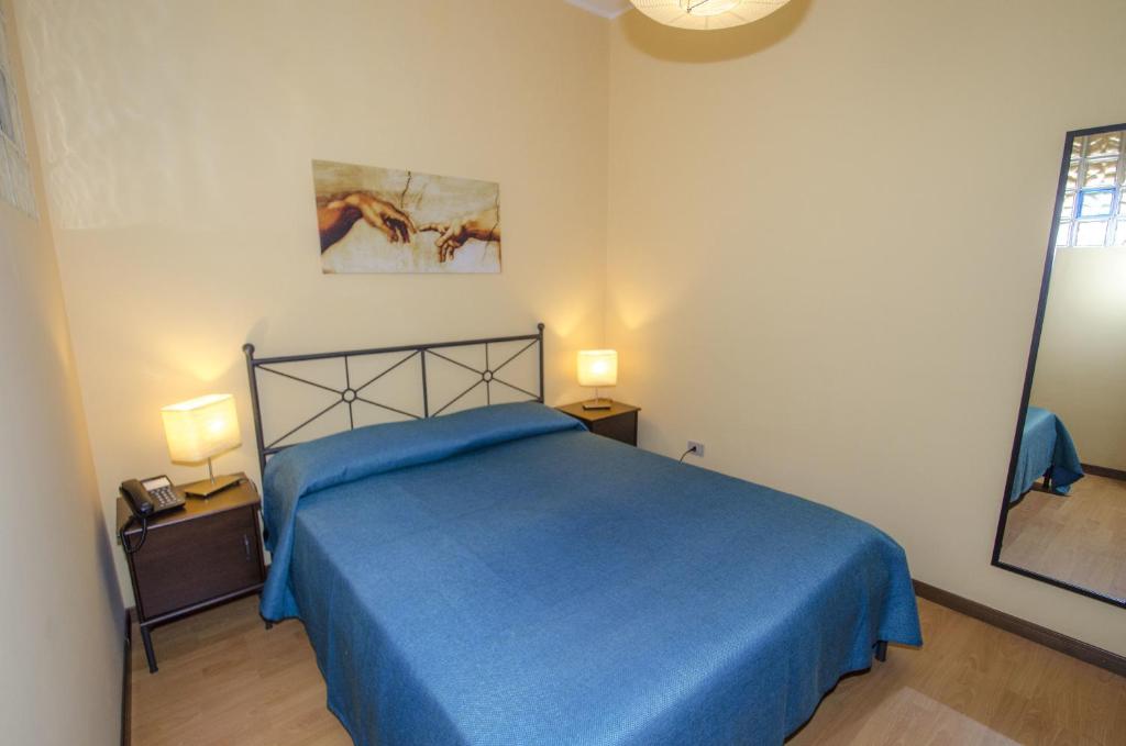 een slaapkamer met een blauw bed en 2 nachtkastjes bij Antico Rione in Caltanissetta