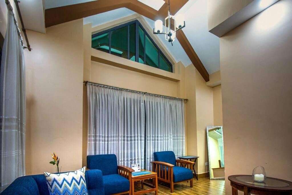 內羅畢的住宿－Opal oasis Residence two，客厅设有蓝色椅子和大窗户
