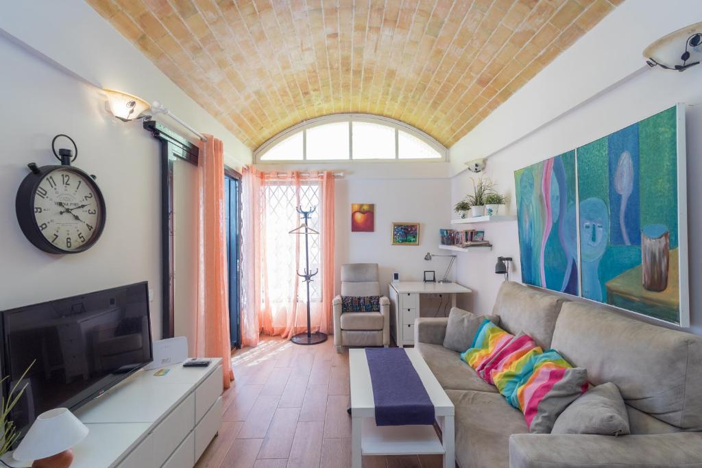 a living room with a couch and a clock at Lightbooking San Agustín next to the beaches in San Bartolomé de Tirajana