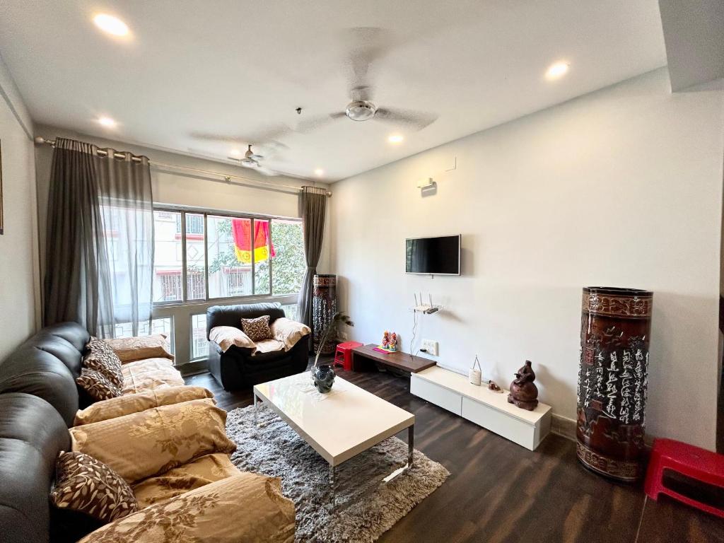 uma sala de estar com um sofá e uma mesa em Lavish 2BHK Apartment in Ballygunge Place with Daily Housekeeping em Calcutá