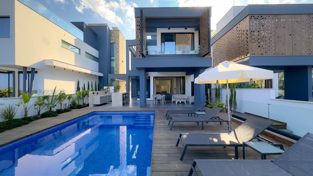 a villa with a swimming pool and a house at Sunrise Beachfront Villas - Villa 3 in Paralimni